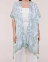 Kimono de gasa ligera con estampado floral en tonos de azul y blanco, silueta amplia, mangas cortas y detalle de borlas en el ruedo asimétrico.