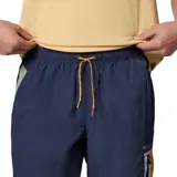 Pantalon cortavientos de hombre en color azul marino con detalles en naranja y verde. Presenta un diseño ligero con cintura elástica ajustable, bolsillos laterales y un bolsillo con cremallera en el muslo. Cuenta con tecnología de repelencia Omni-Shield.