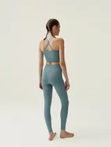 Top deportivo negro de sujeción media con canales para un ajuste perfecto. Presenta patrón delantero halter, tejido Air_feel, tecnología 3D y tirantes finos cruzados en la espalda.