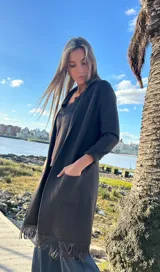 Saco largo marrón con solapa, bolsillos plaqué delanteros y flecos en el ruedo.