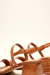 Sandalia de cuero vacuno color negro con textura de cocodrilo, taco cuadrado de 4 cm, punta cuadrada y dos tiras finas, una en el empeine y otra con hebilla en el tobillo.