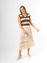 Maxi falda color beige con flecos escalonados y diseño de capas, confeccionada en tela elastizada con cintura elástica.