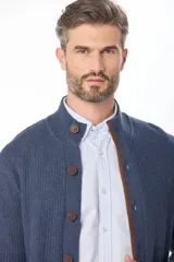 Cardigan de punto grueso color azul marino, con cuello alto, cierre frontal de botones y ribetes en contraste color marrón.