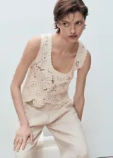 Top de crochet color crudo, sin mangas, con cuello redondo y diseño floral translúcido.