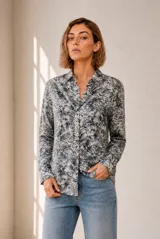 Camisa de manga larga con cierre frontal de botones y cuello camisero, con estampado de hojas en tonos azules y blancos.