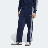 Pantalón deportivo Adidas Firebird Drop Needle de color azul marino, con las clásicas tres tiras blancas en los laterales y el logo del Trifolio bordado. Presenta un diseño de rayas verticales sutiles en relieve.
