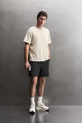 Pantalón corto deportivo de Zara Athleticz confeccionado en tejido técnico ligero y elástico de color negro. Cuenta con cintura elástica ajustable con cordón, bolsillos frontales y aberturas laterales en el bajo.