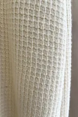 Sweater marrón de punto fantasía, de lana fina sin teñir, con terminaciones elásticas en puños y ruedo.