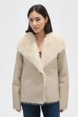 Chaqueta de eco-cuero color beige con interior y cuello de piel sintética en tono crema. Posee cuello solapa amplio, cierre frontal con botón y diseño holgado.