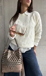 Sweater de punto color natural con diseño de relieve floral en toda la prenda, cuello redondo y mangas largas con puños acanalados.