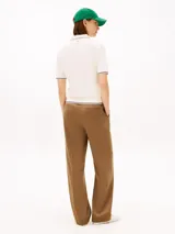 Chomba de piqué color blanco de Tommy Hilfiger, con mezcla de algodón elástico y lyocell. Presenta manga corta, cuello camisero con cierre frontal de cremallera y detalles de líneas oscuras en cuello, puños y dobladillo. Incluye logo bordado en el pecho.