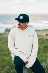 Buzo color crema de corte clásico y tejido acanalado.