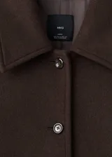 Abrigo largo de lana marrón, diseño recto, con cuello camisero, bolsillos laterales, manga larga y cierre frontal con botones.