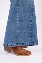 Jean de corte wide leg con costura central vertical en ambas piernas. Presenta un tono denim clásico, tiro medio y cierre frontal con botones.