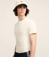 Remera muscle de manga corta confeccionada en media malla color crudo, sin estampa, con cuello redondo.