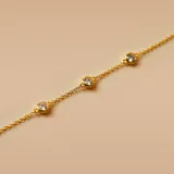 Pulsera dorada con cadena de eslabones y tres circonias engarzadas.