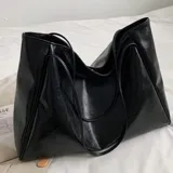 Bolso tipo tote bag color beige claro, de material sintético liso con caída suave. Posee dos asas delgadas para llevar al hombro.