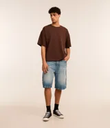 Remera básica de corte overboxy color marrón, con cuello redondo y mangas cortas holgadas.