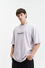 Remera negra de manga corta con corte oversize y cuello redondo. Presenta un estampado pequeño en la espalda con texto en naranja y blanco que dice "Free Spirits Freedom & Waves All Day / Every Day".