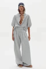 Pantalón de lino de corte ancho con diseño a rayas, tiro alto, bolsillos laterales y pinzas frontales.