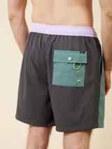 Short de baño verde con cintura lila y cordón de ajuste negro.