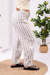 Pantalón de tiro alto y pierna ancha con estampado de rayas verticales en tonos blanco y beige, corte holgado y relajado.