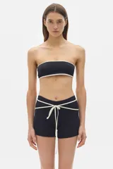 Minishort negro con cintura alta y cordones cruzados blancos.