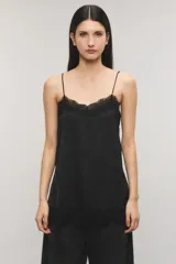 Top negro de satén jacquard, con escote en V de estilo lencero decorado con puntilla delicada al igual que el ruedo, breteles finos regulables y aberturas laterales.