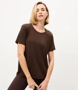 Remera deportiva de manga corta y cuello redondo color marrón, confeccionada en poliamida con elastano. Presenta detalle de recorte en la espalda.