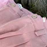 Pantalón de vestir color rosa viejo, de tela tusor, corte holgado y cintura alta con botón.