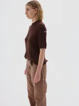 Buzo tejido de manga corta color rojo, con cuello redondo y diseño de punto acanalado y trenzado.