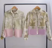 Chaqueta color beige con estampado abstracto en tonos amarillos, con cuello camisero, cierre frontal con botones, bolsillos plaqué y puños camiseros.