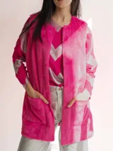 Chaleco largo de piel sintética color blanco, con cuello solapa y dos bolsillos delanteros.