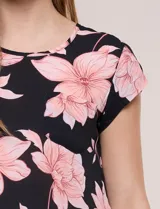 Blusa de gasa ligera con diseño geométrico en tonos oscuros, escote redondo, mangas cortas y bolsillo frontal aplicado. Presenta un ruedo redondeado y silueta relajada.