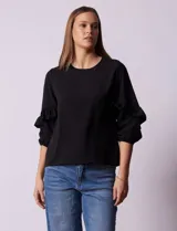 Blusa de gasa estampada con flores azules y violetas sobre fondo blanco, de manga 3/4 con volados.