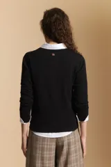 Cardigan negro de tejido suave y liviano, con cierre frontal abotonado y cuello redondo.