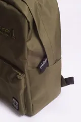 Mochila azul con logo bordado, bolsillos externos y bolsillo escondido al dorso con cierre.