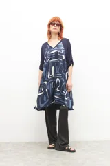 Vestido azul marino con estampado abstracto en blanco y celeste, escote en V y mangas cortas.