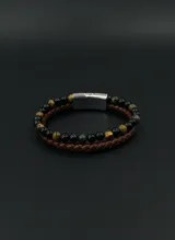 Pulsera doble para hombre que combina una tira de cuero trenzado marrón con una hilera de cuentas de piedra natural en tonos negros y marrones, unidas por un cierre magnético de acero inoxidable.