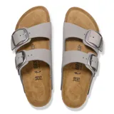 Sandalias Birkenstock modelo Arizona Big Buckle, color gris piedra, con dos correas ajustables de cuero y hebillas metálicas grandes. Presentan plantilla anatómica de corcho y suela de goma negra.