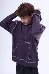 Buzo tipo canguro oversize color violeta oscuro con capucha, bolsillo delantero y estampa gráfica en la espalda con la palabra 'GLOBAL'. Presenta costuras decorativas en contraste.