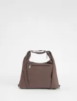 Bolso tipo hobo convertible a mochila, color marrón, con múltiples bolsillos frontales con cierre y herrajes plateados. Incluye un llavero decorativo removible con cuentas de colores y correa regulable.