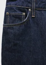 Pantalón de jean azul oscuro, corte wide leg, tiro alto, con cinco bolsillos, trabillas y cierre frontal con cremallera y botón.