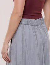 Falda midi color gris de lyocell, con cintura alta, costuras verticales decorativas, bolsillos laterales y corte acampanado.