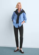 Jeans mom-fit de tiro alto y diseño crop, color negro, con cinco bolsillos, trabillas para cinturón y cierre frontal con cremallera y botón.
