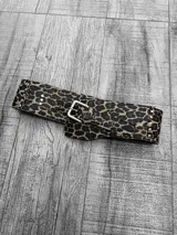 Faja ancha con estampado animal print y tachas plateadas en los bordes. Hebilla metálica plateada.