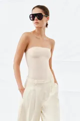 Body strapless de corte ajustado, confeccionado en tejido de poliamida, con cierre inferior mediante botones a presión.