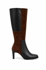 Bota alta bicolor con diseño de paneles en combinación de cuero negro y gamuza marrón. Cuenta con punta cuadrada suave, caña recta alta y taco fino.