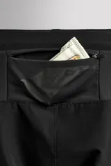 Pantalón de jogging negro confeccionado en tejido técnico ligero y elástico, corte slim fit, con cintura elástica ajustable con cordón, bolsillos laterales y trasero con cierre de cremallera, bandas reflectantes en las piernas y bajos ajustables con cremallera.
