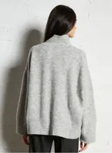 Sweater de punto de corte amplio y holgado, con cuello alto y mangas largas. Confeccionado en una mezcla de lana y alpaca, presenta una textura mullida y compacta.